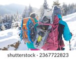 Small photo of Two women walk with snowshoes on the backpacks, winter trekking, two people in the mountains in winter, hiking equipment