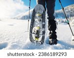 Small photo of a woman with a backpack in snowshoes climbs a snowy mountain, winter trekking, hiking equipment, snowshoes close up
