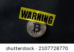 Small photo of Bitcoin virtual currency coin and yellow caution tape with word warning. Concept of economy and money instability