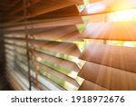 Small photo of Wooden blind on the window with sun rays. Office blinds. Wooden shutters blind.