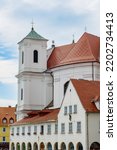 Small photo of Trinity Trinitarian Church in Bratislava, Slovakia. Old Cathedral of Saint John of Matha and Saint Felix of Valois. White church with coper tower roof and red tiles with monastery building in front