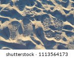 Small photo of Two pairs of steps in a sand. Love trails. Togetherness. Selective focus