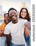 Small photo of Vertical portrait of a group of multiracial young student people smiling taking a selfie together. Happy african american teenager laughing with his cheerful friends. Classmates on friendly meeting