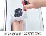 Small photo of Surveillance camera in male hands. Installing a CCTV camera for home security. Copy space.