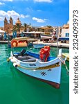 Malta Republic, Malta Island. 28. 06.2023. Marsaxlokk city, The harbor and colorated boats on a hot sunny day.