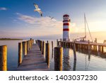 Lighthouse at Lake Neusiedl at sunset near Podersdorf with sea gulls flying around the lighthouse. Burgenland, Austria