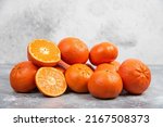 Tangerines (oranges, mandarins, clementines, citrus fruits) with leaves over rustic white stone background with copy space front view, Fresh mandarin orange fruit or tangerines, mandarins oranges.