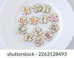 Set of puzzles on a plate with 13 essential micronutrients with multicolored inscriptions icons. Fe, Zn, I, Cu, Me, F, Se, Bor, Si, Cr, V, Co, Mo. Biologically important elements. The concept of