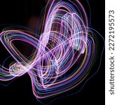 Small photo of Multicolored lines on a black background. Shooting a multicolored garland in motion on a slow shutter speed.