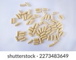 Small photo of Beige capsules with lactase on a white background. Digestive aid, lactose and casein intolerance. Tablets, supplements, medications