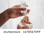 Disinfecting hands. Taking disinfection alcohol gel on hands in white light to prevent virus epidemic. Prevention of flu disease. Cleaning and disinfecting hands in proper way.