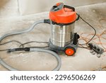 Small photo of Vacuum cleaner in renovating dusty room. Professional cleaning up after renovation concept. Building vacuum and dirty unfinished room after house construction