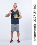 Small photo of Happy smile senior man portrait holding bowl of vegan fruit and vegetable on isolated background. Healthy senior people with healthy vegetarian nutrition and body care lifestyle. Clout