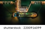 Small photo of Aerial top view oil tanker ship at terminal industrial port at night for transfer crude oil to oil refinery, Business import export oil and gas petrochemical.