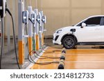 EV charging an electric car. Power supply for electric car charging. Socket for electrical car battery charger. EV car charging station in parking. Nature energy, Clean energy, Green eco concept.