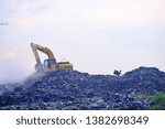 Small photo of Kaliwungu, Indonesia - 28 April 2019 : large and high garbage disposal locations, there are excavators that dredge up garbage and there are people who are looking for used goods