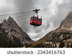Cable car Lagazuoi Dolomiti from Passo di Falzarego to the Mount Lagazuoi. Bright red gondola between two mountains. Falzarego Pass, near Cortina d'Ampezzo. Belluno, Italy.
