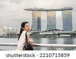 Woman traveling on bay waterfront against Marina Bay Sands into Singapore city downtown. 