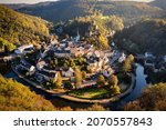 Small photo of Aerial view of Esch-sur-Sure, medieval town in Luxembourg, dominated by castle, canton Wiltz in Diekirch. Forests of Upper-Sure Nature Park, meander of winding river Sauer, near Upper Sauer Lake.