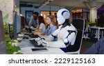 Robot working at computer among ...