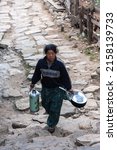 Small photo of Phakding, Nepal - 10 Mar 2012 A Sherpa woman carries utensils for cooking.