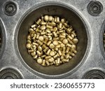 Small photo of Pile of Rivets, a world of potential. Uniform brassy, gold colored aluminum rivets in a tray. Metal fasteners used in sheet metal work on planes, cars, buildings. Industrial hardware for major work