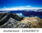 the photo shows the landscape of Norwegian mountains above the fjord