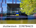 Flag of Ukraine in the courtyard of an office building. Flag holiday. The river is next to the building.