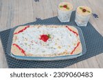 Small photo of Delicious trifle or tipsy pudding in glass tray or plate topped with cherry.