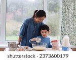 Small photo of Mum and child making cake. Mixing cake batter in a mixing glass bowl for baking cake waffle pancake. Child holding whisk mixing flour, eggs, milk for pancake day.Family healthy lifestyle concept.