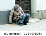 Poor Homeless Man Sitting Near...