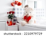 Valentine's day, lovers' day with red flowers, a white teddy bear holding a big red heart