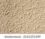 Small photo of Decorative plaster shagreen. Improvement of the wall of the building. Texture of rough plaster. Coarse-grained concrete background. Rough wall surface