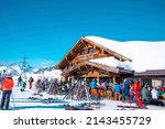 Small photo of St. Anton am Arlberg. March 10, 2022. People sitting at outdoor cafe at ski resort chalet during skiing holiday, Tourists sitting at mountain cafe on sunny day