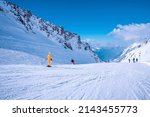 Small photo of St. Anton am Arlberg. March 10, 2022. People in ski wear sliding down slope on snowy mountain at ski resort during beautiful sunny day, Skiers skiing downhill on snowy mountain