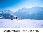 Small photo of St. Anton am Arlberg. March 10, 2022. People with ski wear and poles standing on slope against snow covered mountains, Skiers with poles standing on mountain slope at ski resort