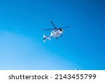 Small photo of St. Anton am Arlberg. March 10, 2022. Police helicopter in flight against blue sky during sunny day, Police helicopter flying above