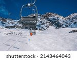 Small photo of St. Anton am Arlberg. March 10, 2022. Empty chairlifts on mountain slope at ski resort during beautiful sunny day, Skilifts against snowcapped mountains