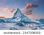 Idyllic view of snowcapped matterhorn mountain peak. Famous snow covered landscape against sky during sunset. Beautiful snowy valley in alps during winter.