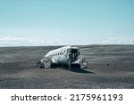 Famous broken airplane wreck at black sand beach. Abandoned military aircraft in Solheimasandur against sky. Scenic view of tourist attraction on volcanic landscape.