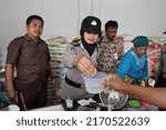 Small photo of Kebumen, Indonesia - May, 2015: Policewomen check rice at the Kebumen traditional market in relation to the issue of plastic made rice.