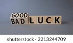 Small photo of Good Luck and bad Luck symbol. Turned wooden cubes with words Bad Luck and Good Luck. Beautiful grey background. Business concept. Copy space