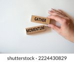 Small photo of Gather momentum symbol. Wooden blocks with words Gather momentum. Beautiful white background. Businessman hand. Business and Gather momentum concept. Copy space.