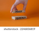 Small photo of Pivot quickly symbol. Wooden blocks with words Pivot quickly. Businessman hand. Beautiful orange background. Business and Pivot quickly concept. Copy space.