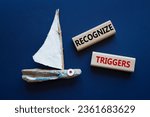Small photo of Recognize triggers symbol. Concept words Recognize triggers on wooden blocks. Beautiful deep blue background with boat. Business and Recognize triggers concept. Copy space.