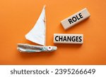 Small photo of Role changes symbol. Concept words Role changes on wooden blocks. Beautiful deep blue background with boat. Business and Role changes concept. Copy space.