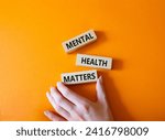Small photo of Mental Health Matters symbol. Concept words Mental Health Matters on wooden blocks. Beautiful orange background. Doctor hand. Healthcare and Mental Health Matters concept. Copy space.