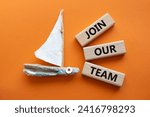 Small photo of Join our team symbol. Wooden blocks with words Join our team. Beautiful orange background with boat. Business and Join our team concept. Copy space.