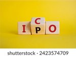 Small photo of ICO and IPO symbol. Wooden cubes with words ICO - initial coin offering and IPO - initial public offering. Beautiful yellow background. Business concept. Copy space