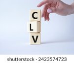 Small photo of CLV - Customer Lifetime Value symbol. Concept word CLV on wooden cubes. Businessman hand. Beautiful white background. Business and CLV concept. Copy space.